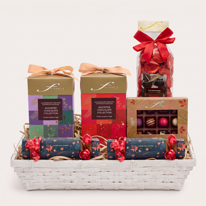 “Fardoulis Christmas Reindeer Chocolate Gift Hamper in a white basket with ribbon-tied chocolate boxes, a red-bowed chocolate bag and two festive bonbons.”