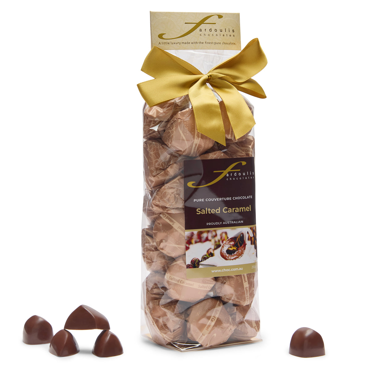 “Fardoulis salted caramel chocolates in a clear gift bag tied with a gold satin bow, with loose chocolates beside it.”