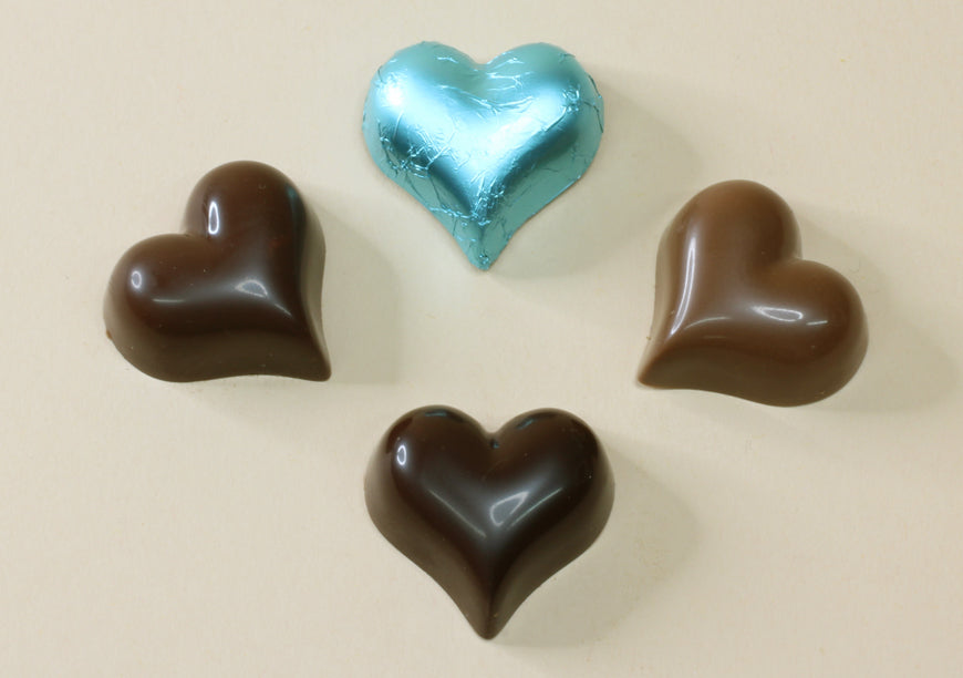 Shop aqua foiled chocolate hearts in milk or dark chocolate, made from pure couverture chocolate. Perfect for favours, gifts and special occasions.