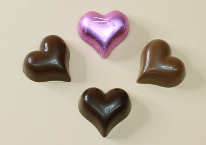 Shop lilac foiled chocolate hearts in milk or dark chocolate, made from pure couverture chocolate. Perfect for favours, gifts and special occasions.