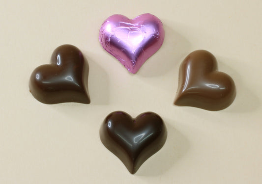 Shop lilac foiled chocolate hearts in milk or dark chocolate, made from pure couverture chocolate. Perfect for favours, gifts and special occasions.