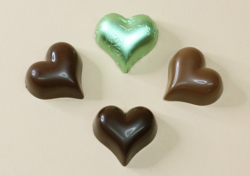 Shop pastel green foiled chocolate hearts in mint creme, milk or dark chocolate, made from pure couverture chocolate. Perfect for favours and gifts.