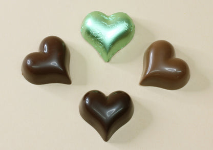 Shop pastel green foiled chocolate hearts in mint creme, milk or dark chocolate, made from pure couverture chocolate. Perfect for favours and gifts.