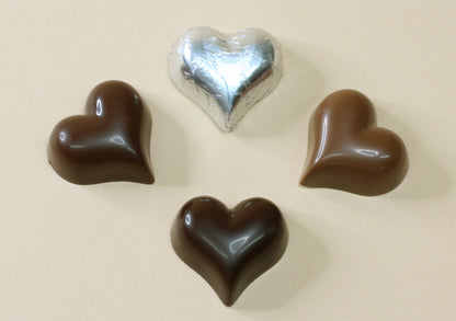 Shop shiny silver foil heart chocolates, 10g each, made with pure couverture chocolate. Choose solid milk or solid dark chocolate for favours and gifts.