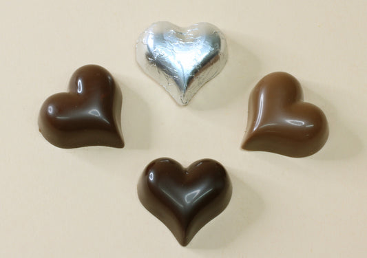 Shop shiny silver foil heart chocolates, 10g each, made with pure couverture chocolate. Choose solid milk or solid dark chocolate for favours and gifts.